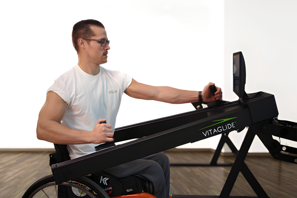 Man using wheelchair exercise equipment indoors.